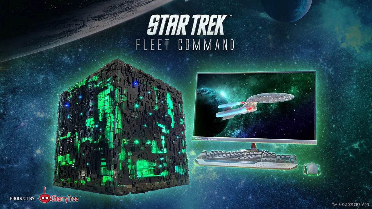 A PC case shaped like a Borg cube beside a monitor showing the Enterprise-D, a keyboard and a mouse.