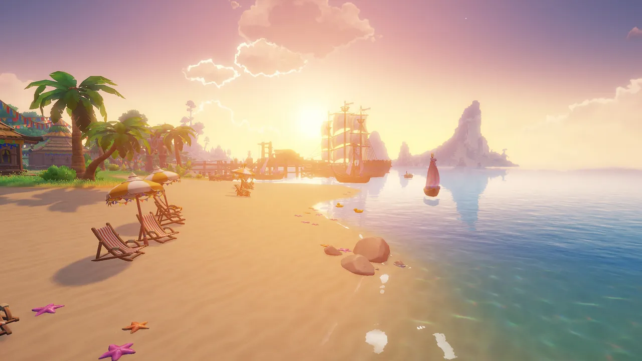 Sunset over a sandy beach with striped deck chairs, a harbour with sailing ships and rock islands in the distance.